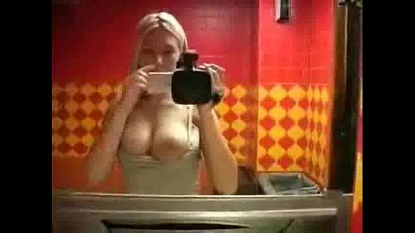 Blonde woman gets surprised while using the bathroom
