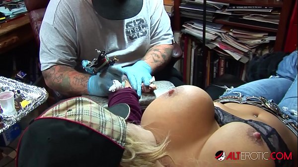 Shyla Stylez plays with her big boobs while getting tattooed in a softcore solo scene